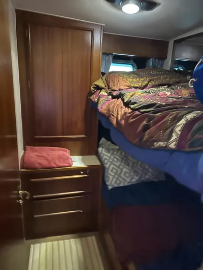 Charisma Yacht Photos Pics Cozy cabin interior of 1987 Post 46 SPORT with wooden cabinetry and colorful bedding.