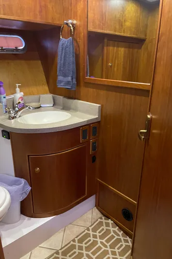  Yacht Photos Pics Luxurious bathroom in 2002 Canoe Cove 50 Pilothouse Yacht with wooden cabinetry and modern fixtures.