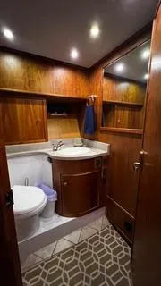  Yacht Photos Pics Luxurious bathroom in 2002 Canoe Cove 50 Pilothouse Yacht with wood accents and modern fixtures.