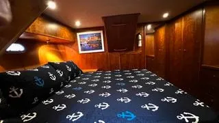  Yacht Photos Pics Luxurious bedroom in 2002 Canoe Cove 50 Pilothouse Yacht with nautical-themed bedding.