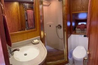  Yacht Photos Pics Luxurious bathroom in 2002 Canoe Cove 50 Pilothouse Yacht with wood accents and modern fixtures.