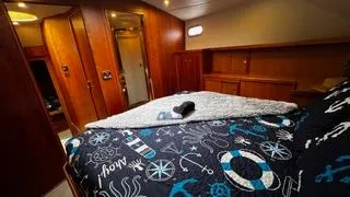  Yacht Photos Pics Luxurious bedroom interior of 2002 Canoe Cove 50 Pilothouse Yacht with nautical-themed bedding.