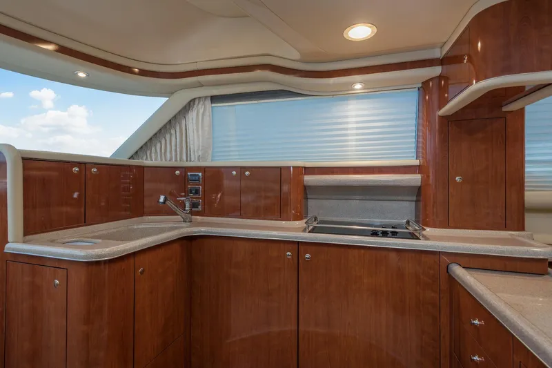 Lattitude Adjustment Yacht Photos Pics Luxurious kitchen interior of 2003 Sea Ray 480 Sedan Bridge yacht with wood cabinetry.