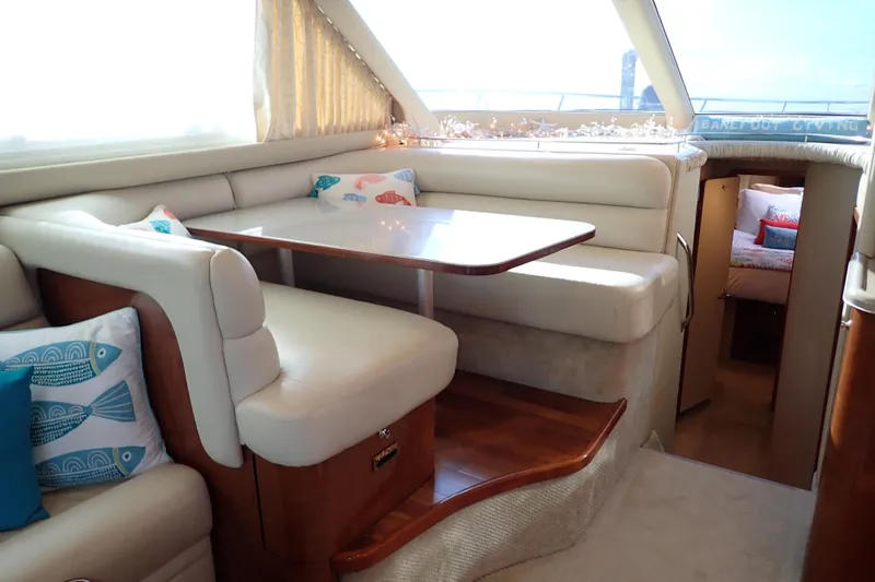 Lattitude Adjustment Yacht Photos Pics Luxurious interior of 2003 Sea Ray 480 Sedan Bridge with cozy seating and decorative pillows.