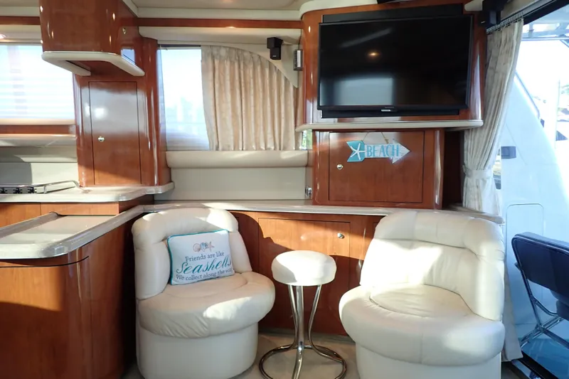 Lattitude Adjustment Yacht Photos Pics Luxurious interior of 2003 Sea Ray 480 Sedan Bridge yacht with plush seating and TV.