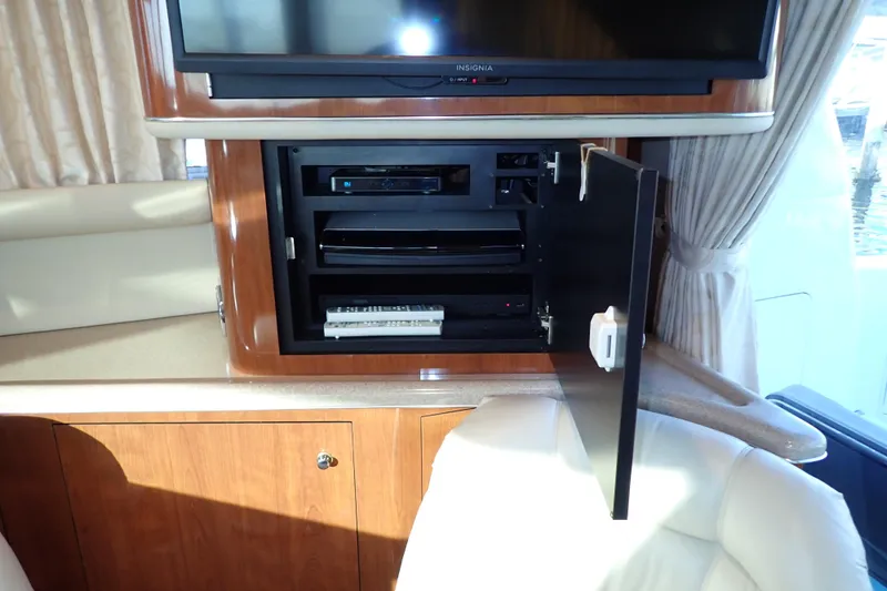 Lattitude Adjustment Yacht Photos Pics Interior of 2003 Sea Ray 480 Sedan Bridge with entertainment system cabinet open.