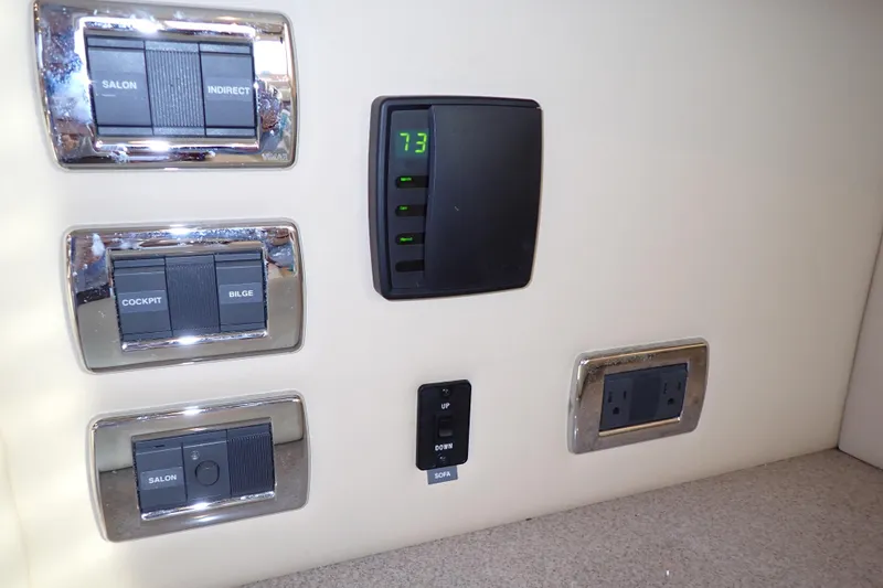Lattitude Adjustment Yacht Photos Pics Control panel of a 2003 Sea Ray 480 Sedan Bridge yacht, featuring switches and outlets.