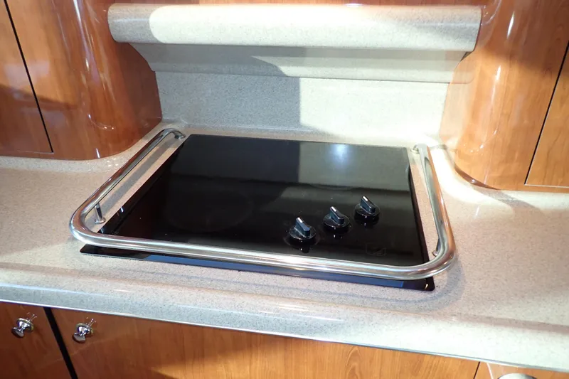 Lattitude Adjustment Yacht Photos Pics Stovetop in 2003 Sea Ray 480 Sedan Bridge yacht kitchen, featuring sleek design.