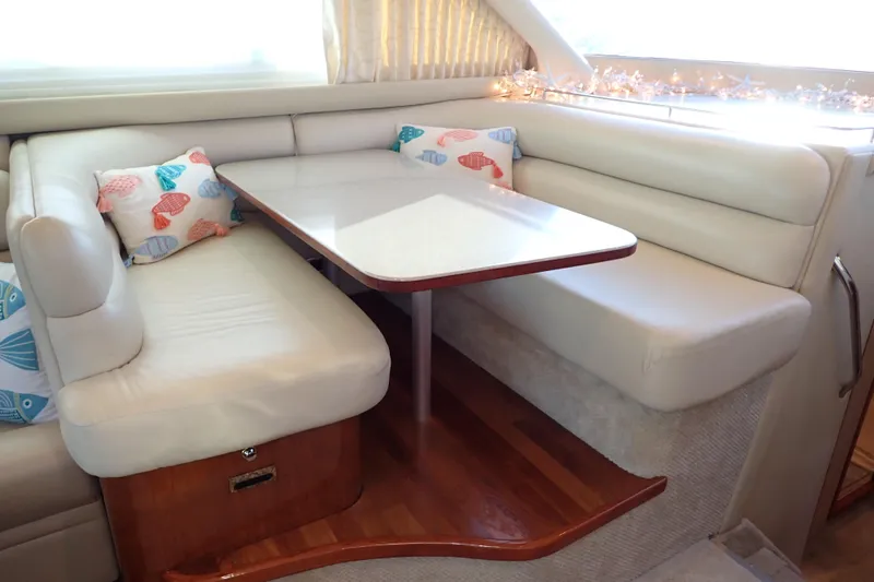 Lattitude Adjustment Yacht Photos Pics 2003 Sea Ray 480 Sedan Bridge interior with white leather seating and decorative pillows.