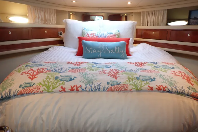 Lattitude Adjustment Yacht Photos Pics Luxurious 2003 Sea Ray 480 Sedan Bridge cabin with colorful bedding and "Stay Salty" pillow.