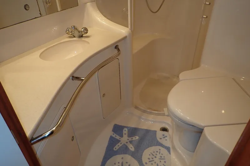 Lattitude Adjustment Yacht Photos Pics Bathroom interior of 2003 Sea Ray 480 Sedan Bridge yacht, featuring sink and toilet.