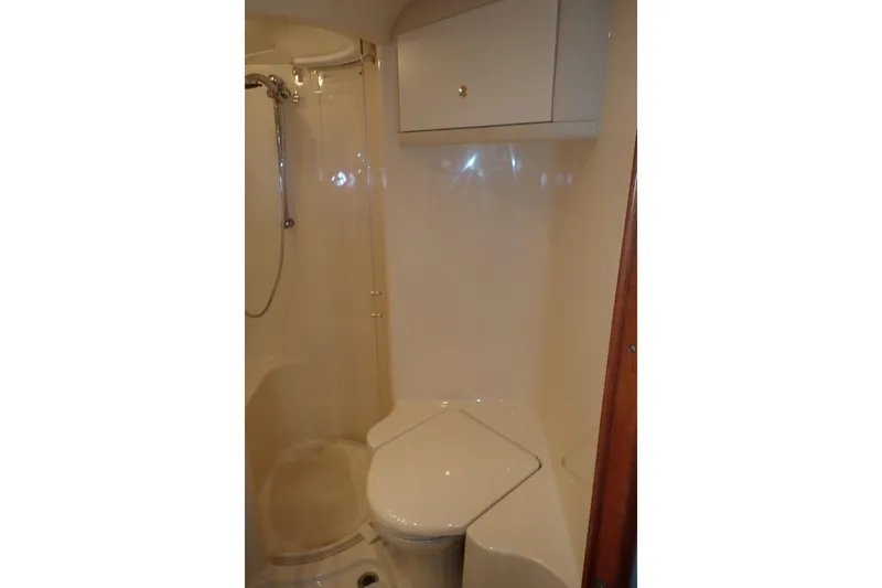 Lattitude Adjustment Yacht Photos Pics Bathroom interior of 2003 Sea Ray 480 Sedan Bridge yacht, featuring shower and toilet.