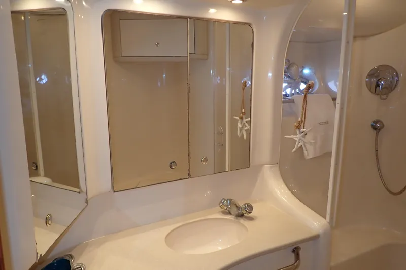 Lattitude Adjustment Yacht Photos Pics Bathroom interior of 2003 Sea Ray 480 Sedan Bridge yacht, featuring mirror and sink.