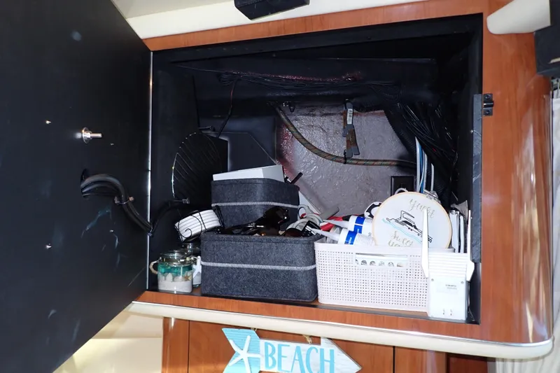 Lattitude Adjustment Yacht Photos Pics Storage compartment on a 2003 Sea Ray 480 Sedan Bridge, filled with various items.
