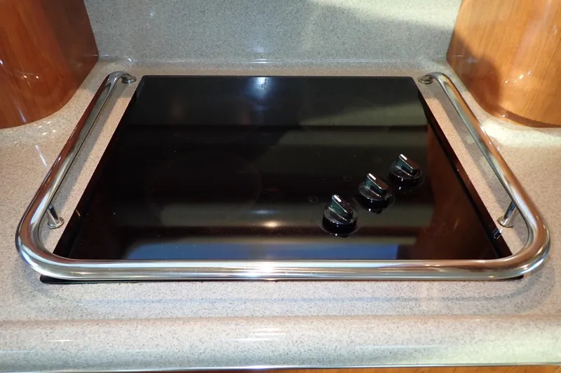 Lattitude Adjustment Yacht Photos Pics Stovetop on 2003 Sea Ray 480 Sedan Bridge yacht, featuring sleek black surface and control knobs.