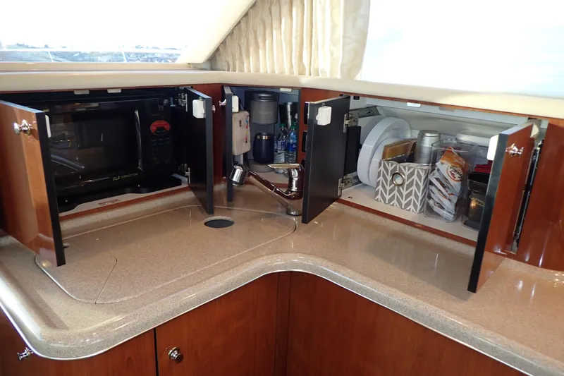 Lattitude Adjustment Yacht Photos Pics 2003 Sea Ray 480 Sedan Bridge yacht kitchen with open cabinets and countertop.