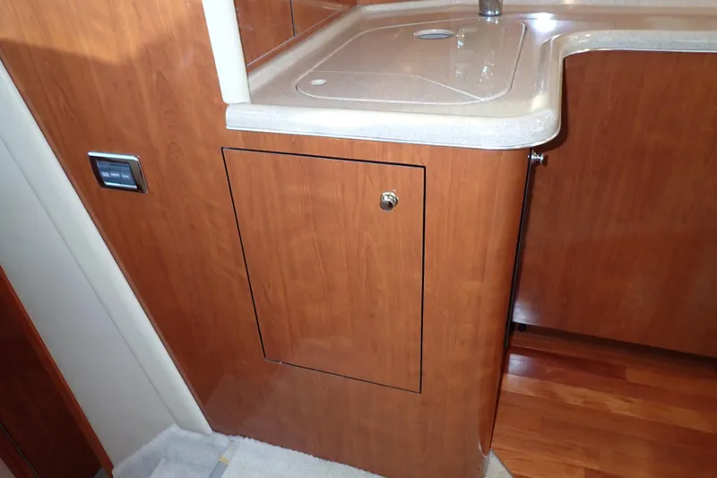 Lattitude Adjustment Yacht Photos Pics 2003 Sea Ray 480 Sedan Bridge interior with wooden cabinetry and sink.
