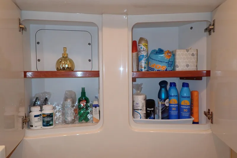 Lattitude Adjustment Yacht Photos Pics Cabinet with toiletries and cleaning supplies on a 2003 Sea Ray 480 Sedan Bridge.