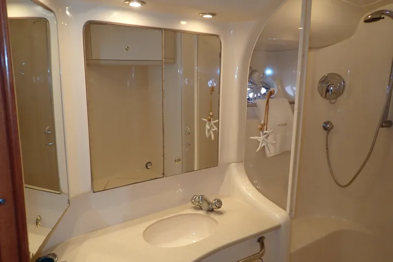 Lattitude Adjustment Yacht Photos Pics Luxurious bathroom in 2003 Sea Ray 480 Sedan Bridge yacht, featuring elegant fixtures and mirrors.