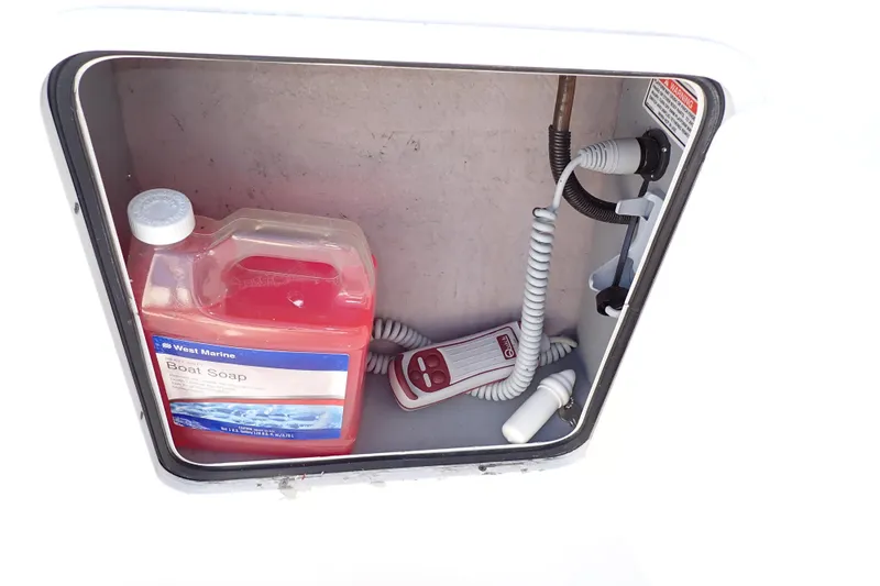Lattitude Adjustment Yacht Photos Pics Storage compartment on a 2003 Sea Ray 480 Sedan Bridge with boat soap and coiled hose.