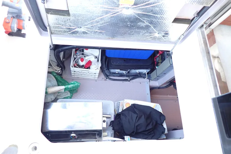 Lattitude Adjustment Yacht Photos Pics Storage compartment of 2003 Sea Ray 480 Sedan Bridge with various equipment and supplies.