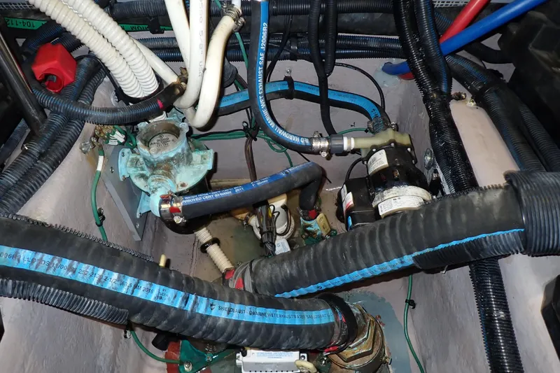 Lattitude Adjustment Yacht Photos Pics Engine compartment of a 2003 Sea Ray 480 Sedan Bridge with visible hoses and wiring.