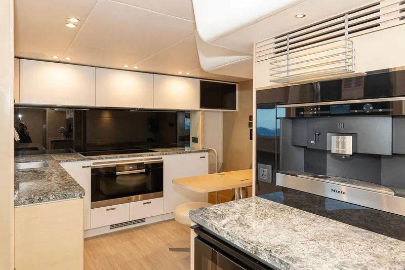 Nadira Yacht Photos Pics Modern yacht kitchen with granite countertops, Miele appliances, and sleek cabinetry in a 2019 Princess 30M.