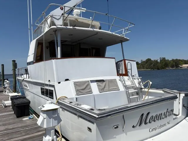  Yacht Photos Pics 1990 Carver Californian 52 yacht docked, rear view, named "Moonstruck," sunny day, calm waters.