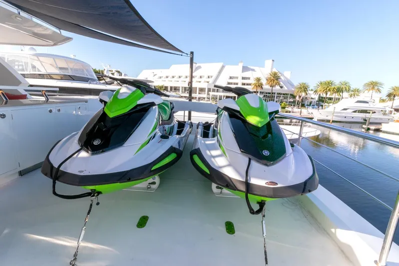 One More Time Yacht Photos Pics Two green and white jet skis on a Horizon FD92 yacht deck, 2021 model, in a marina.