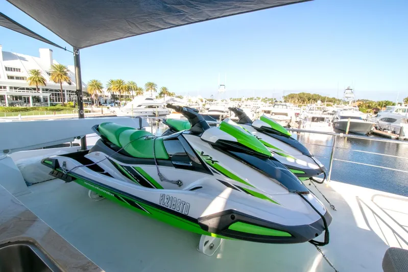 One More Time Yacht Photos Pics Green and white jet skis on Horizon FD92 yacht, 2021 model, docked at marina.