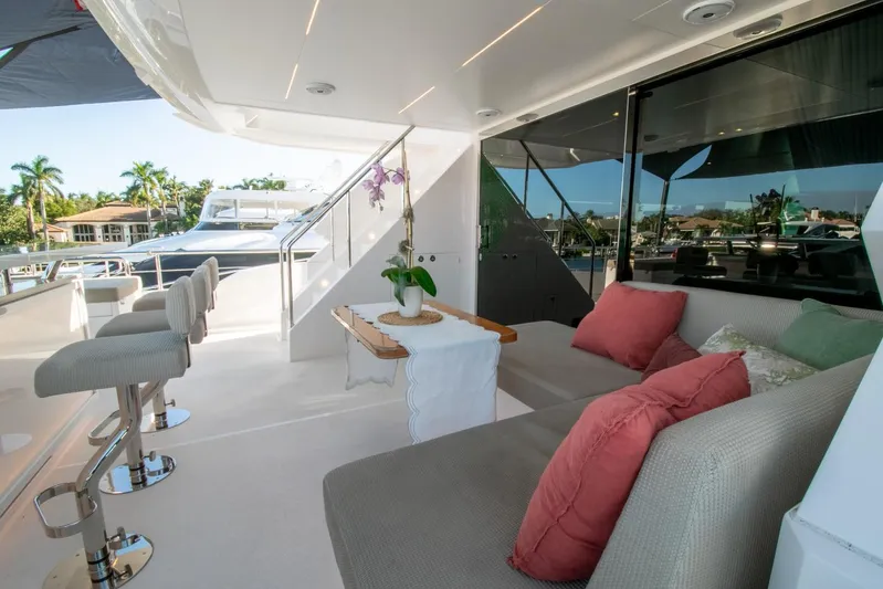 One More Time Yacht Photos Pics Luxurious Horizon FD92 yacht deck with seating, bar stools, and tropical view, 2021 model.