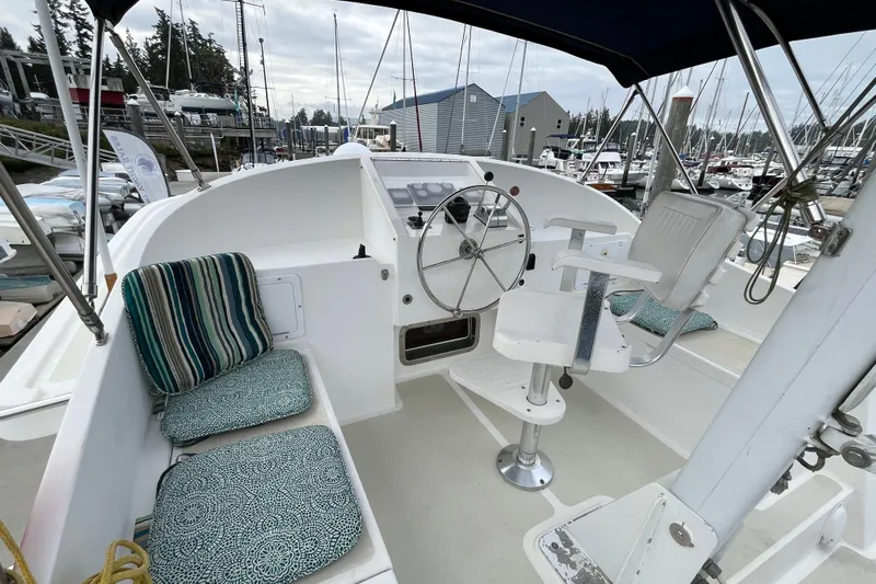 Abina Yacht Photos Pics 2001 Kadey-Krogen 39 boat cockpit with steering wheel and cushioned seating at marina.