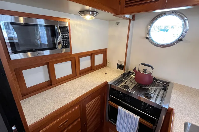 Abina Yacht Photos Pics 2001 Kadey-Krogen 39 yacht kitchen with microwave, stove, and porthole window.