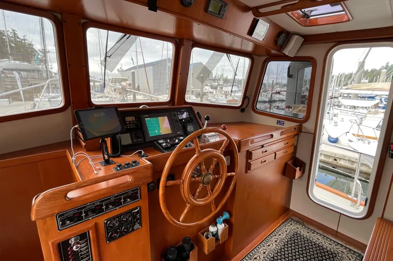 Abina Yacht Photos Pics Pilothouse interior of 2001 Kadey-Krogen 39 yacht with wooden steering wheel and navigation equipment.