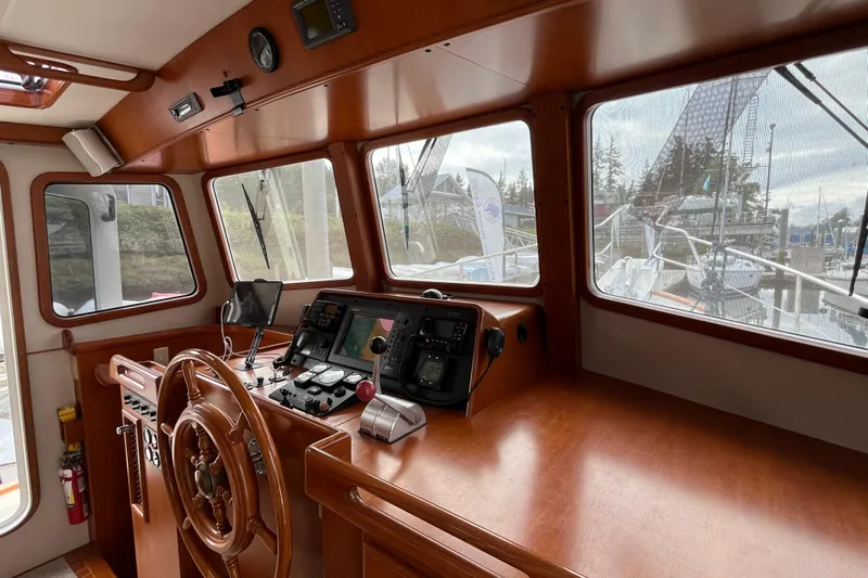 Abina Yacht Photos Pics Pilothouse of 2001 Kadey-Krogen 39 yacht with wooden helm and navigation equipment.
