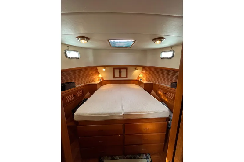 Abina Yacht Photos Pics Cozy bedroom in 2001 Kadey-Krogen 39 yacht with wooden furnishings and soft lighting.