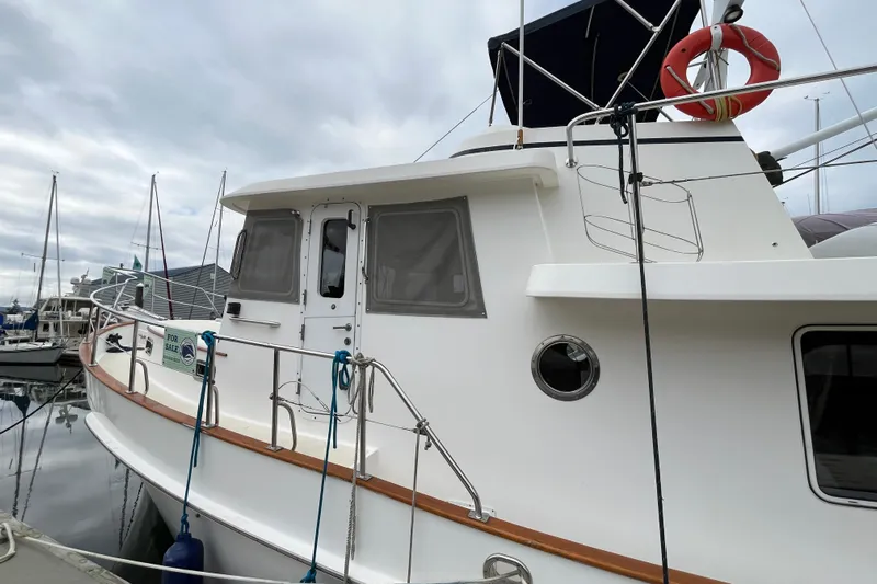 Abina Yacht Photos Pics 2001 Kadey-Krogen 39 yacht docked, for sale, with lifebuoy and overcast sky.