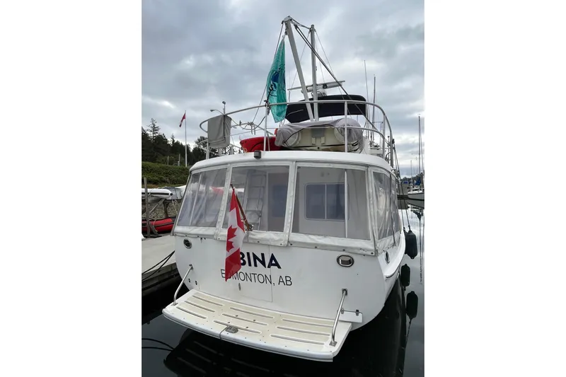 Abina Yacht Photos Pics 2001 Kadey-Krogen 39 boat docked, displaying Canadian flag, overcast sky.