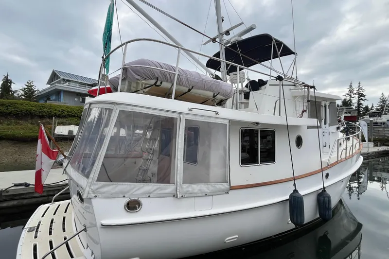 Abina Yacht Photos Pics 2001 Kadey-Krogen 39 yacht docked, featuring Canadian flag and covered upper deck.