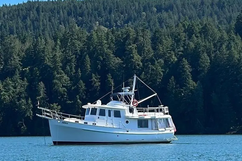 Abina Yacht Photos Pics 2001 Kadey-Krogen 39 yacht anchored on serene water with forest backdrop.