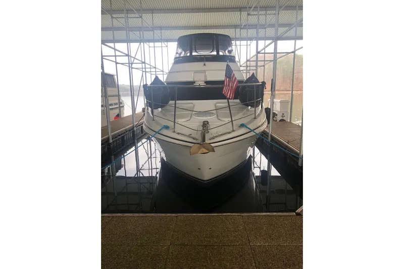 Fire Away Yacht Photos Pics 2005 Carver 444 Cockpit Motor Yacht docked with American flag displayed.