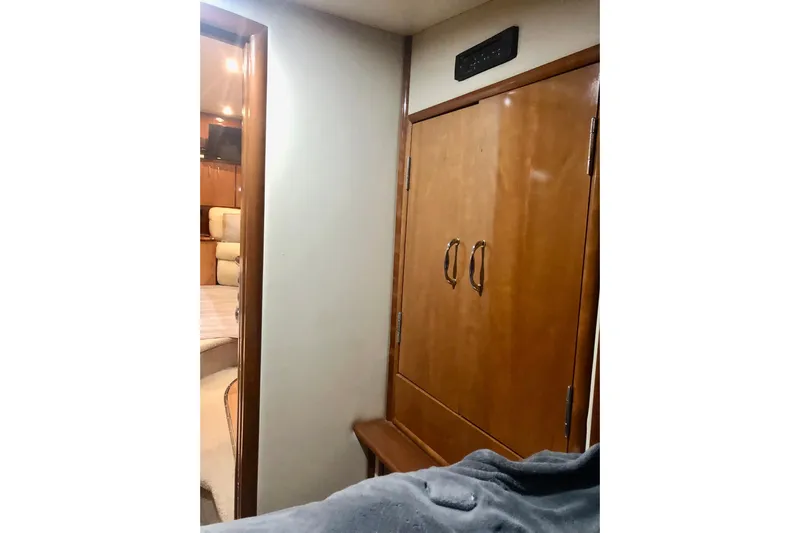 Fire Away Yacht Photos Pics Interior of 2005 Carver 444 Cockpit Motor Yacht with wooden cabinetry and cozy bedroom.