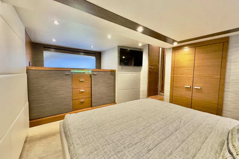  Yacht Photos Pics Luxurious interior of 2020 Tiara Yachts F53 Flybridge, featuring modern cabinetry and cozy bedding.