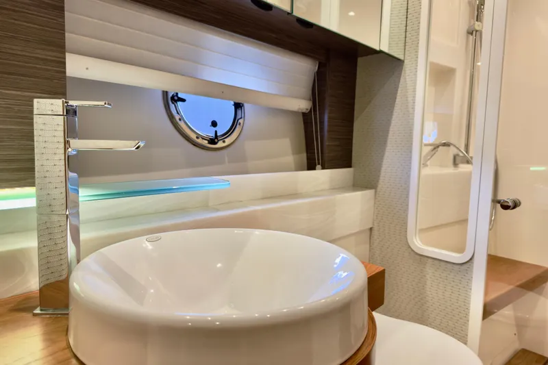  Yacht Photos Pics Luxurious bathroom interior of 2020 Tiara Yachts F53 Flybridge with modern sink and porthole.