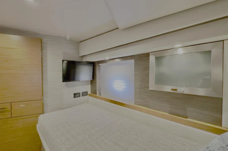 Yacht Photos Pics Interior of 2020 Tiara Yachts F53 Flybridge, featuring a modern bedroom with TV and storage.