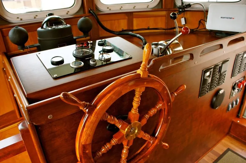  Yacht Photos Pics Wooden helm and controls of a 2010 Custom Trawler boat interior.