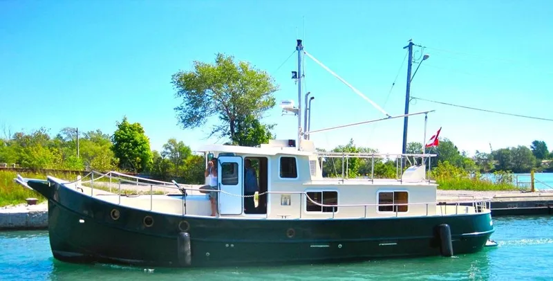  Yacht Photos Pics Custom 2010 trawler boat docked on a sunny day, with lush greenery in the background.