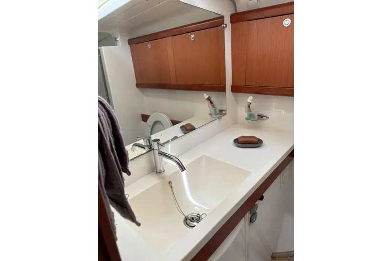  Yacht Photos Pics Bathroom interior of 2008 Beneteau 49 yacht with sink, mirror, and wooden cabinets.