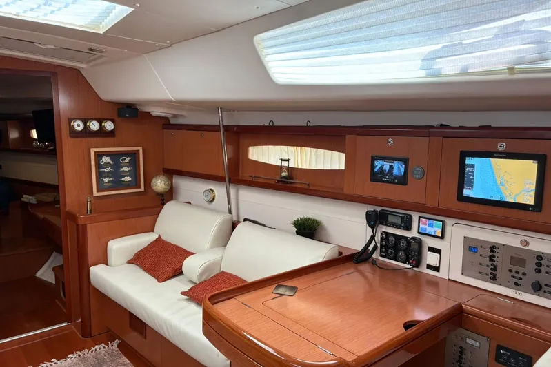  Yacht Photos Pics Interior of 2008 Beneteau 49 yacht with navigation equipment and cozy seating area.