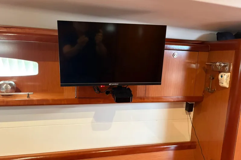  Yacht Photos Pics Interior of 2008 Beneteau 49 yacht with mounted TV and wooden cabinetry.